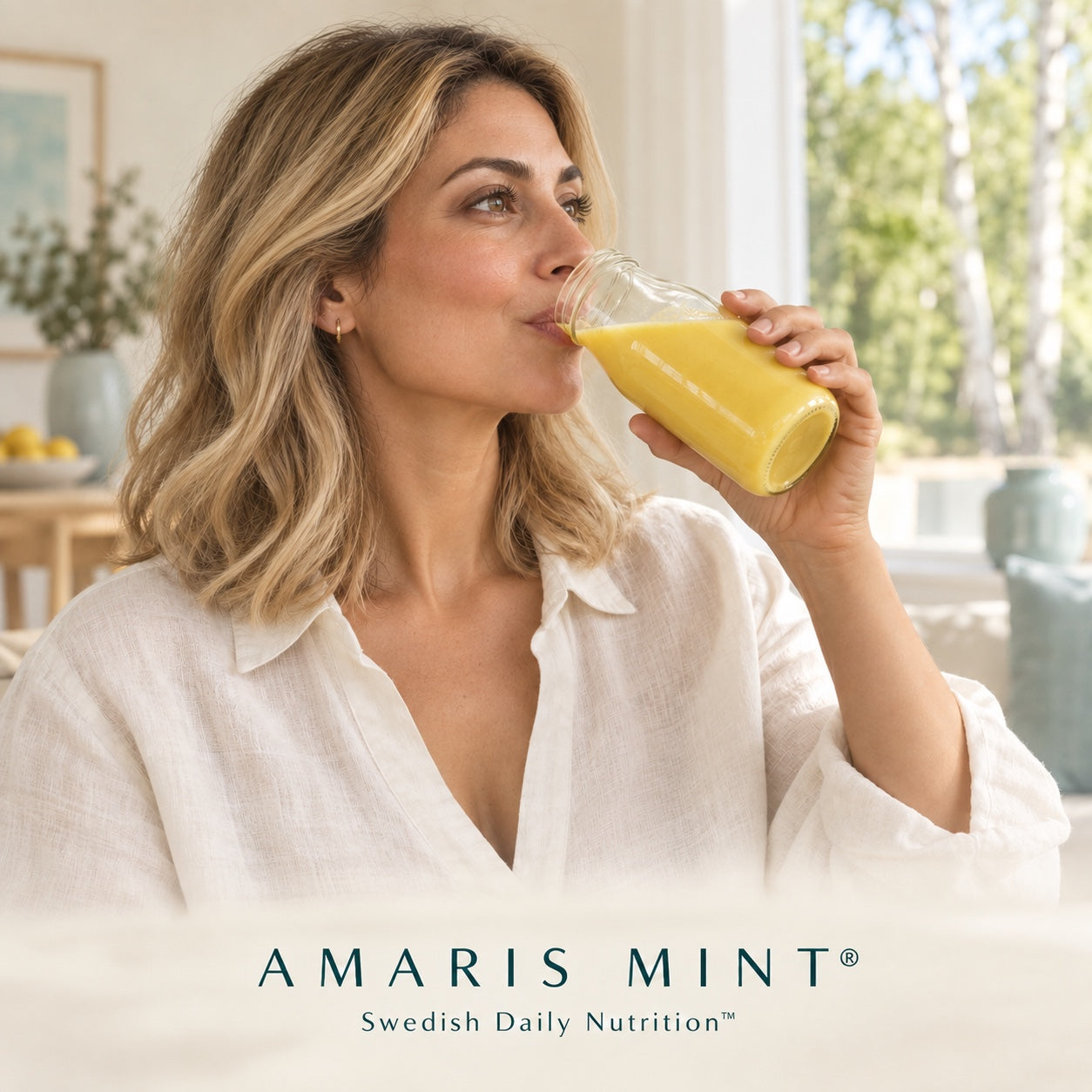 Woman drinking an Amaris Mint daily nutrition shake in a bright Nordic home